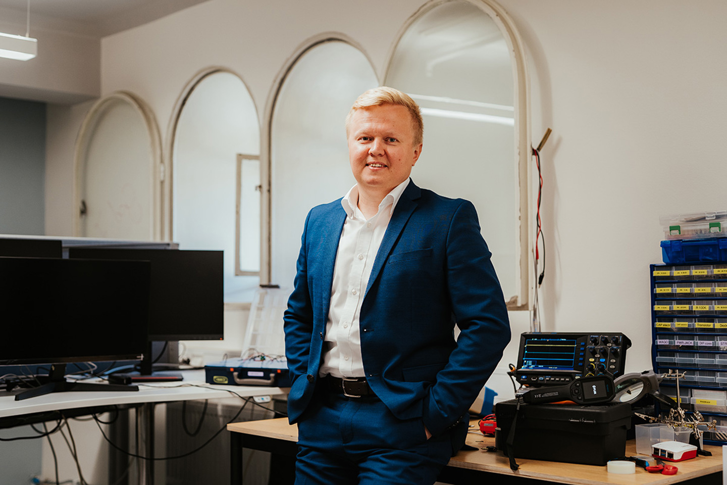 Andrii står i laboratoriet foran pc-skjerm og diverse utstyr som brukes på laben.